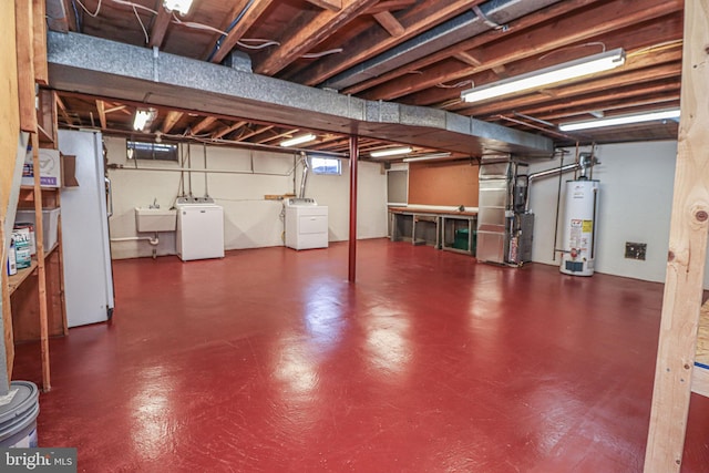 basement featuring gas water heater, heating unit, separate washer and dryer, sink, and white fridge