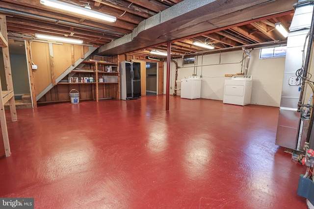 basement with black refrigerator and separate washer and dryer