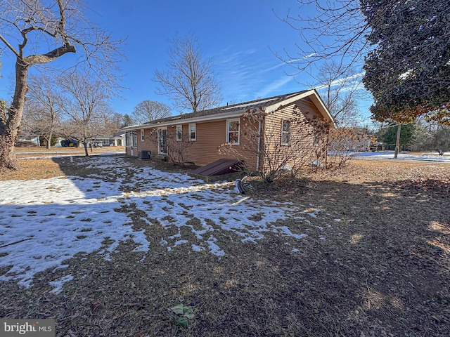 snow covered property featuring central AC unit