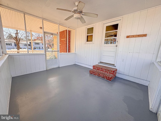 unfurnished sunroom featuring ceiling fan and a healthy amount of sunlight