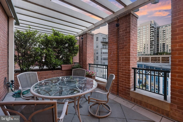 balcony at dusk featuring a pergola