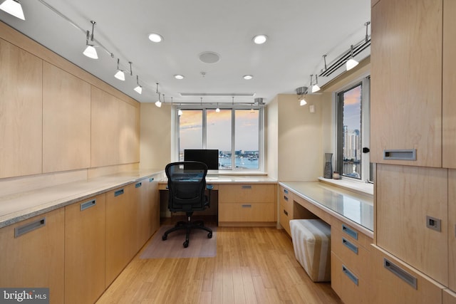 office area with built in desk and light wood-type flooring