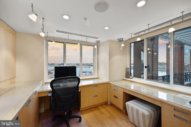 home office featuring built in desk and light hardwood / wood-style flooring