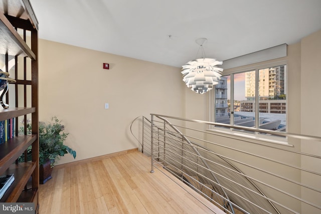 corridor featuring a notable chandelier and light wood-type flooring