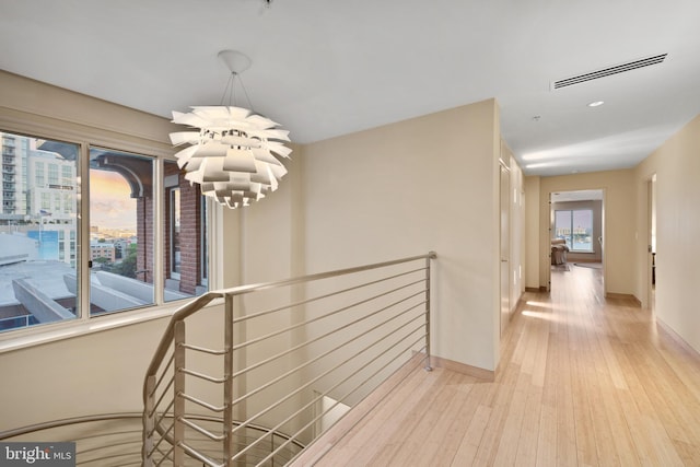 hallway with a chandelier and light hardwood / wood-style flooring