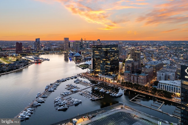 aerial view at dusk featuring a water view