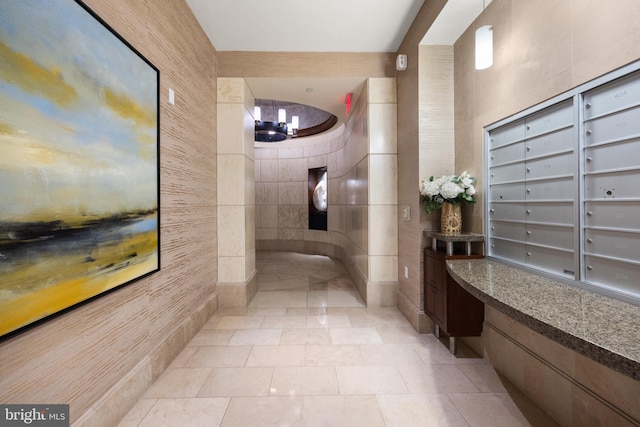 bathroom featuring tile patterned flooring, mail boxes, and tile walls