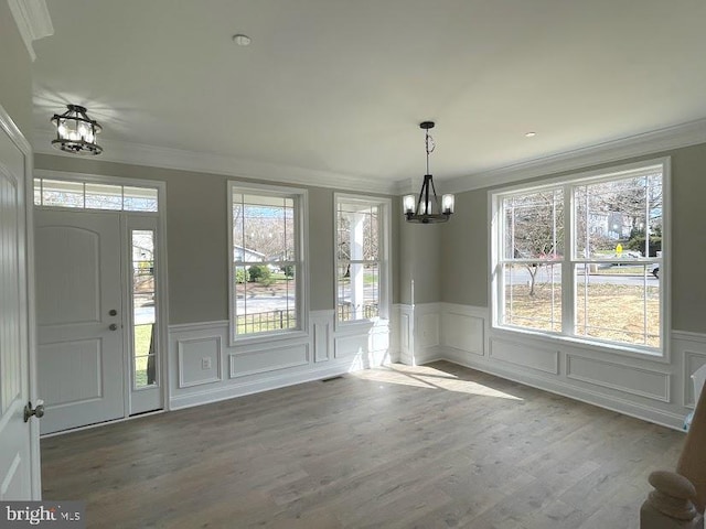 1394 B And A Blvd, Arnold, MD 21012 - unfurnished dining area featuring a chandelier, crown molding, wainscoting, a decorative wall, and wood finished floors