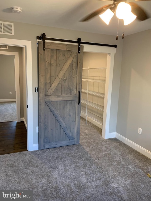 1394 B And A Blvd, Arnold, MD 21012 - unfurnished bedroom with carpet flooring, a barn door, baseboards, and ceiling fan