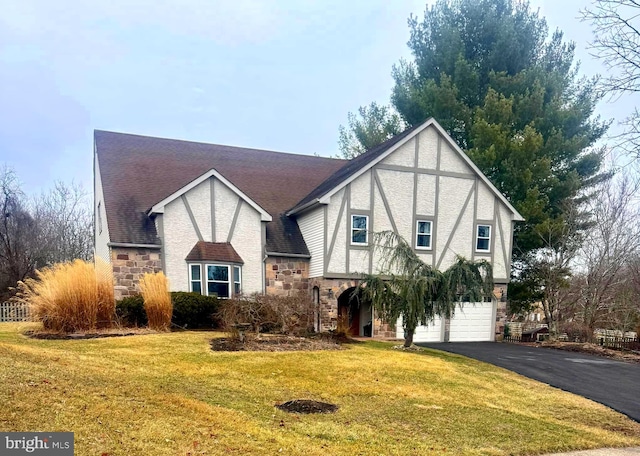 english style home with a front yard and a garage