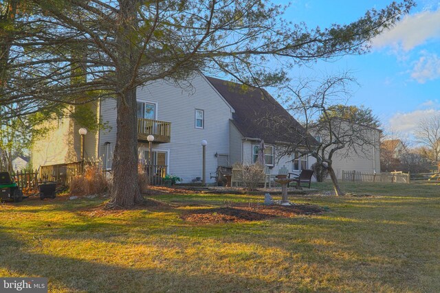 view of side of property with a yard and a balcony