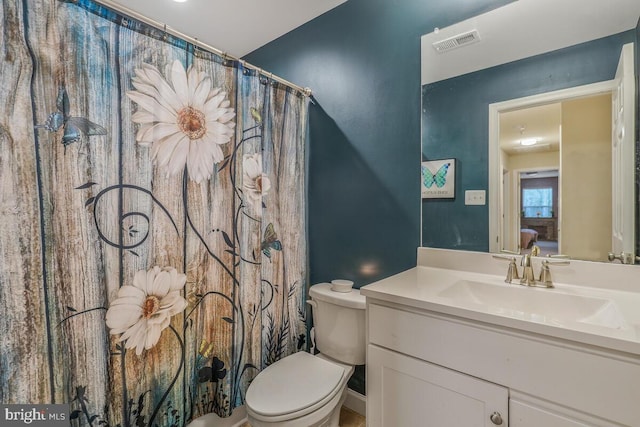 bathroom with vanity, curtained shower, and toilet