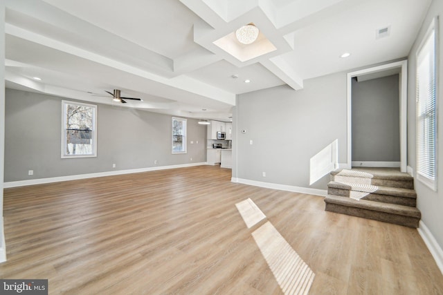 unfurnished living room featuring ceiling fan and light wood-type flooring