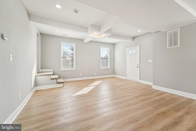 interior space with light hardwood / wood-style flooring and beamed ceiling