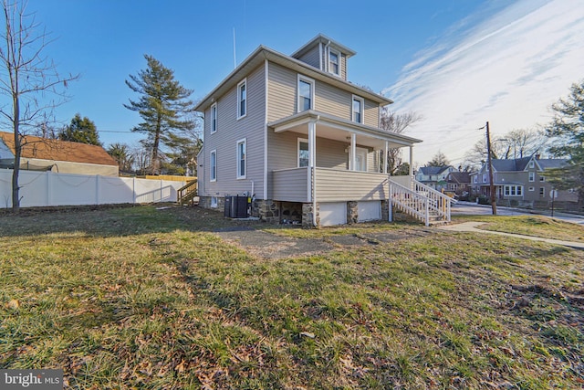 back of house featuring a yard, covered porch, and central air condition unit