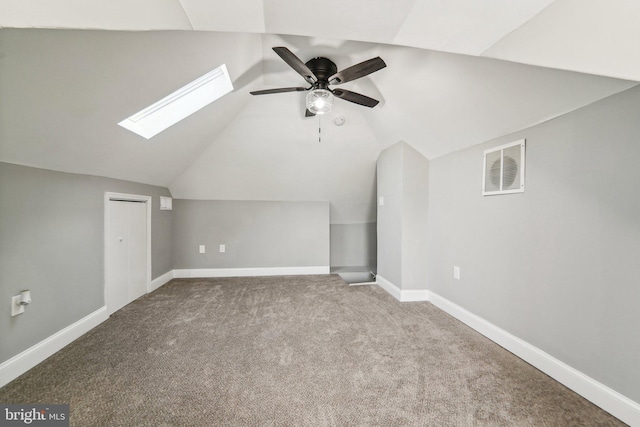 additional living space featuring ceiling fan, carpet flooring, and lofted ceiling with skylight