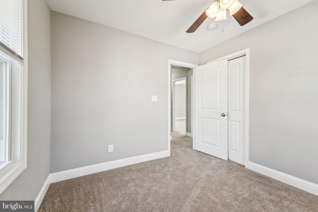 unfurnished bedroom featuring ceiling fan, a closet, and light carpet