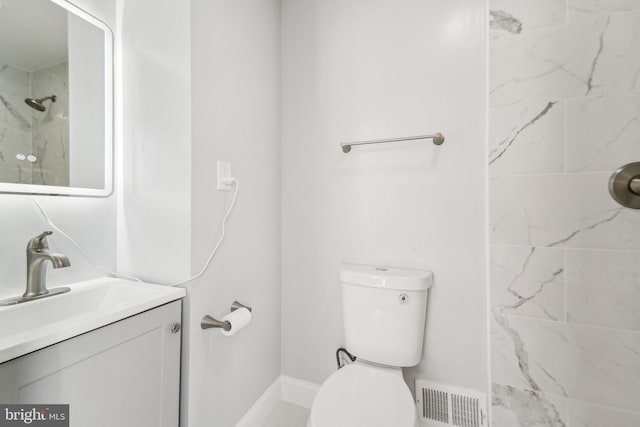 bathroom featuring vanity, toilet, and tiled shower