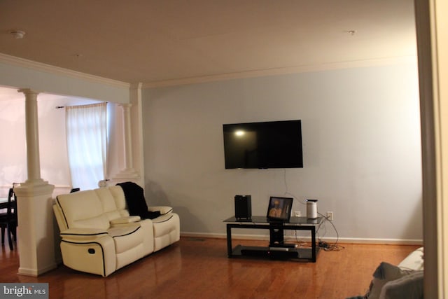 living room featuring decorative columns, crown molding, and wood-type flooring