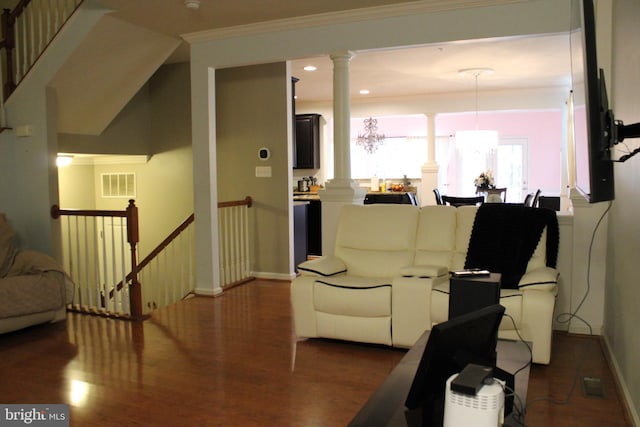 living room with dark wood-type flooring, ornamental molding, and decorative columns