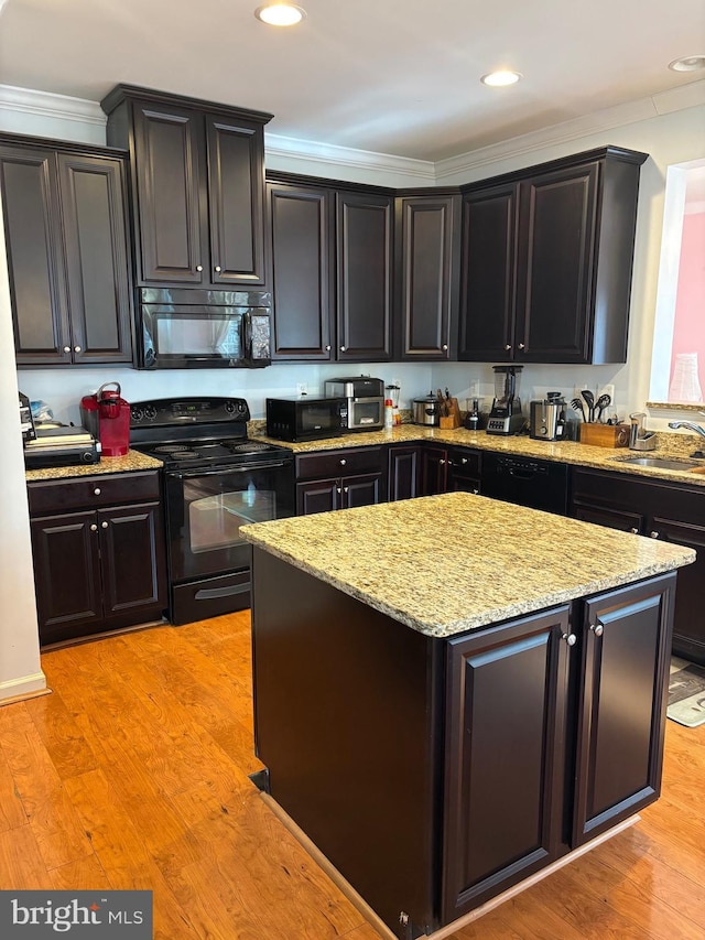 kitchen with light stone counters, sink, light hardwood / wood-style flooring, and black appliances