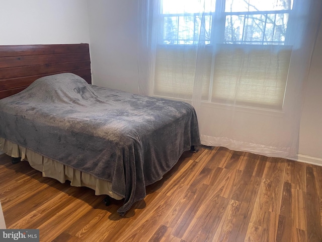 bedroom with multiple windows and hardwood / wood-style floors