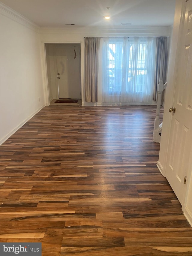 spare room featuring crown molding and dark hardwood / wood-style floors