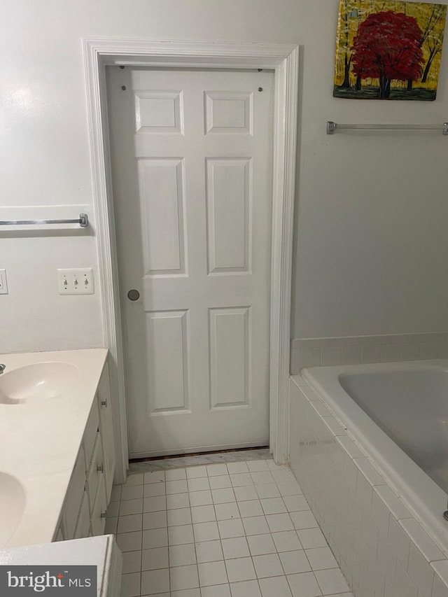 bathroom featuring vanity, a relaxing tiled tub, and tile patterned floors