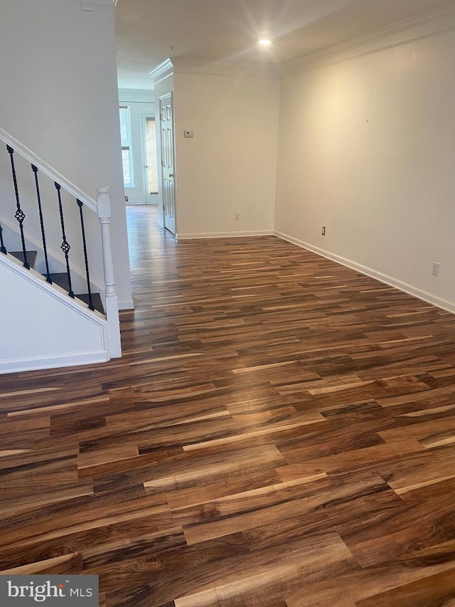 spare room featuring dark hardwood / wood-style flooring and crown molding