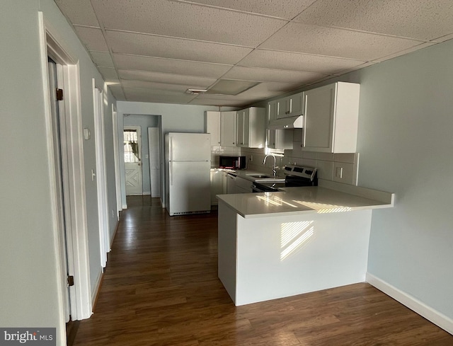 kitchen featuring stainless steel electric range, white refrigerator, dark hardwood / wood-style floors, kitchen peninsula, and decorative backsplash