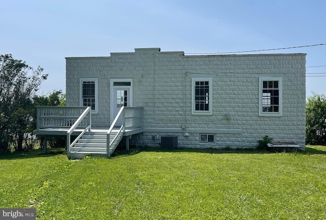 rear view of house with a wooden deck and a yard