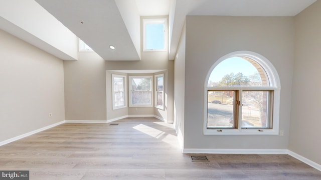 unfurnished living room with light hardwood / wood-style floors and a wealth of natural light