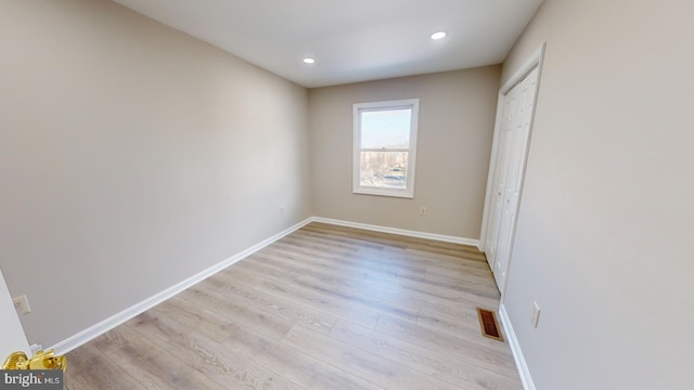 unfurnished bedroom featuring light hardwood / wood-style floors and a closet