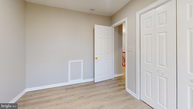 unfurnished bedroom with a closet and light hardwood / wood-style flooring