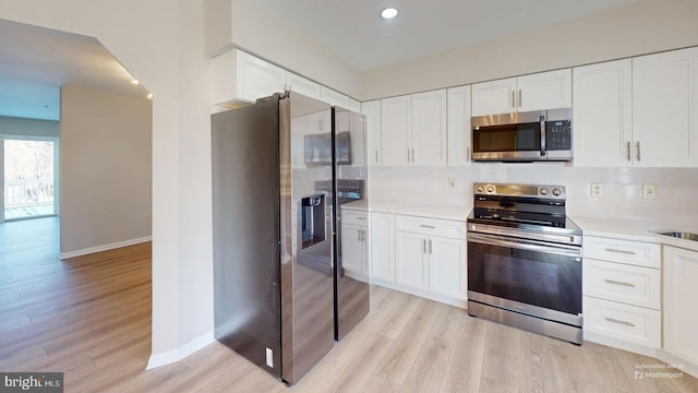 kitchen featuring light wood-type flooring, white cabinets, and appliances with stainless steel finishes