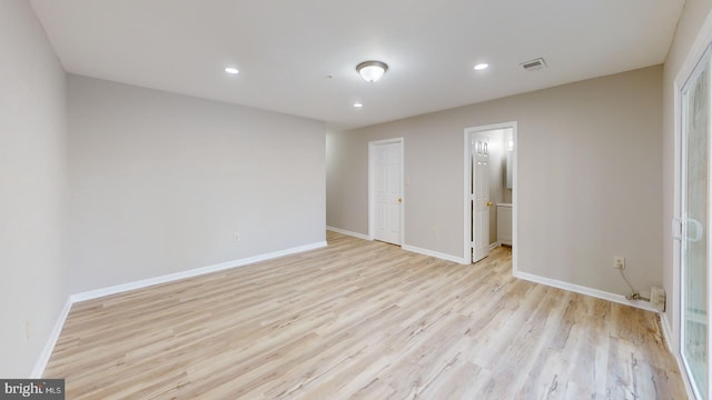 unfurnished bedroom featuring ensuite bathroom and light hardwood / wood-style floors