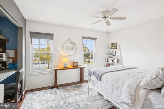 bedroom featuring multiple windows, hardwood / wood-style floors, and ceiling fan