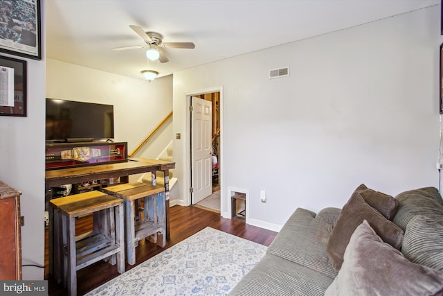 living room featuring ceiling fan and dark hardwood / wood-style floors