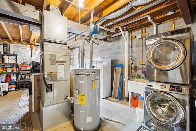 basement featuring stacked washer / dryer and electric water heater