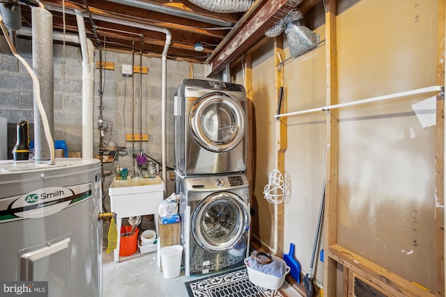 laundry room featuring water heater and stacked washing maching and dryer