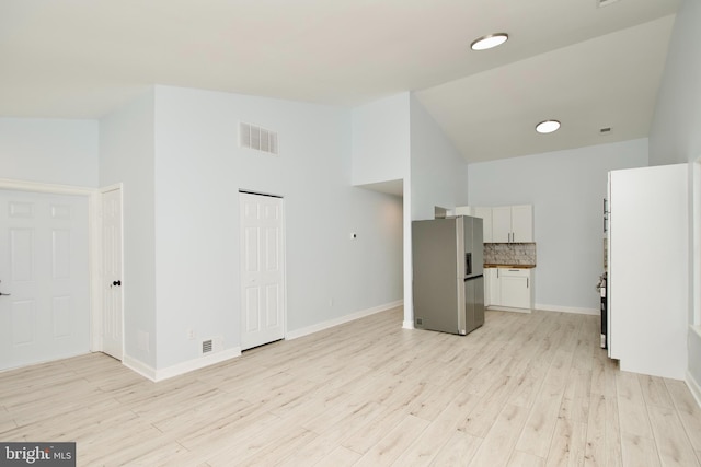 interior space featuring vaulted ceiling and light wood-type flooring