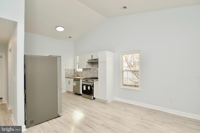 kitchen with white cabinetry, high vaulted ceiling, light wood-type flooring, stainless steel appliances, and backsplash