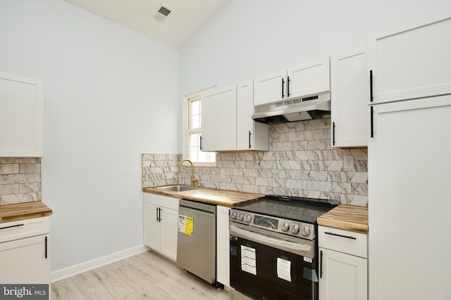 kitchen with wood counters, sink, white cabinetry, appliances with stainless steel finishes, and decorative backsplash