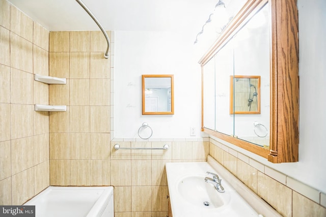 bathroom featuring vanity and tile walls