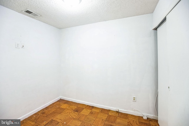 unfurnished room with a textured ceiling