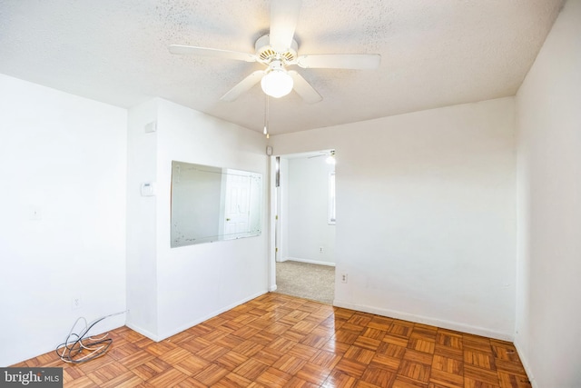 unfurnished room with a textured ceiling, light parquet floors, and ceiling fan