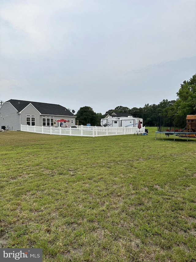 view of yard with a playground and a trampoline