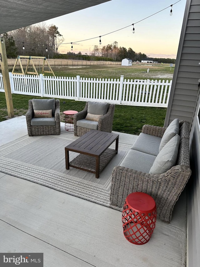 deck at dusk featuring a playground, a patio, and a yard