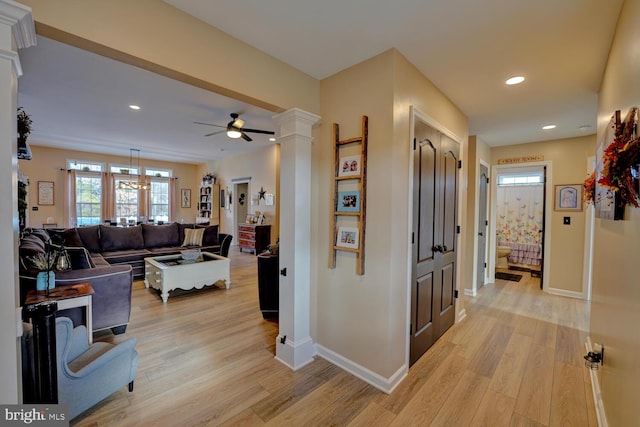 hall featuring light hardwood / wood-style floors and ornate columns