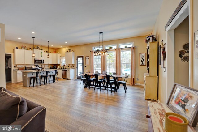 dining space with a chandelier and light hardwood / wood-style flooring